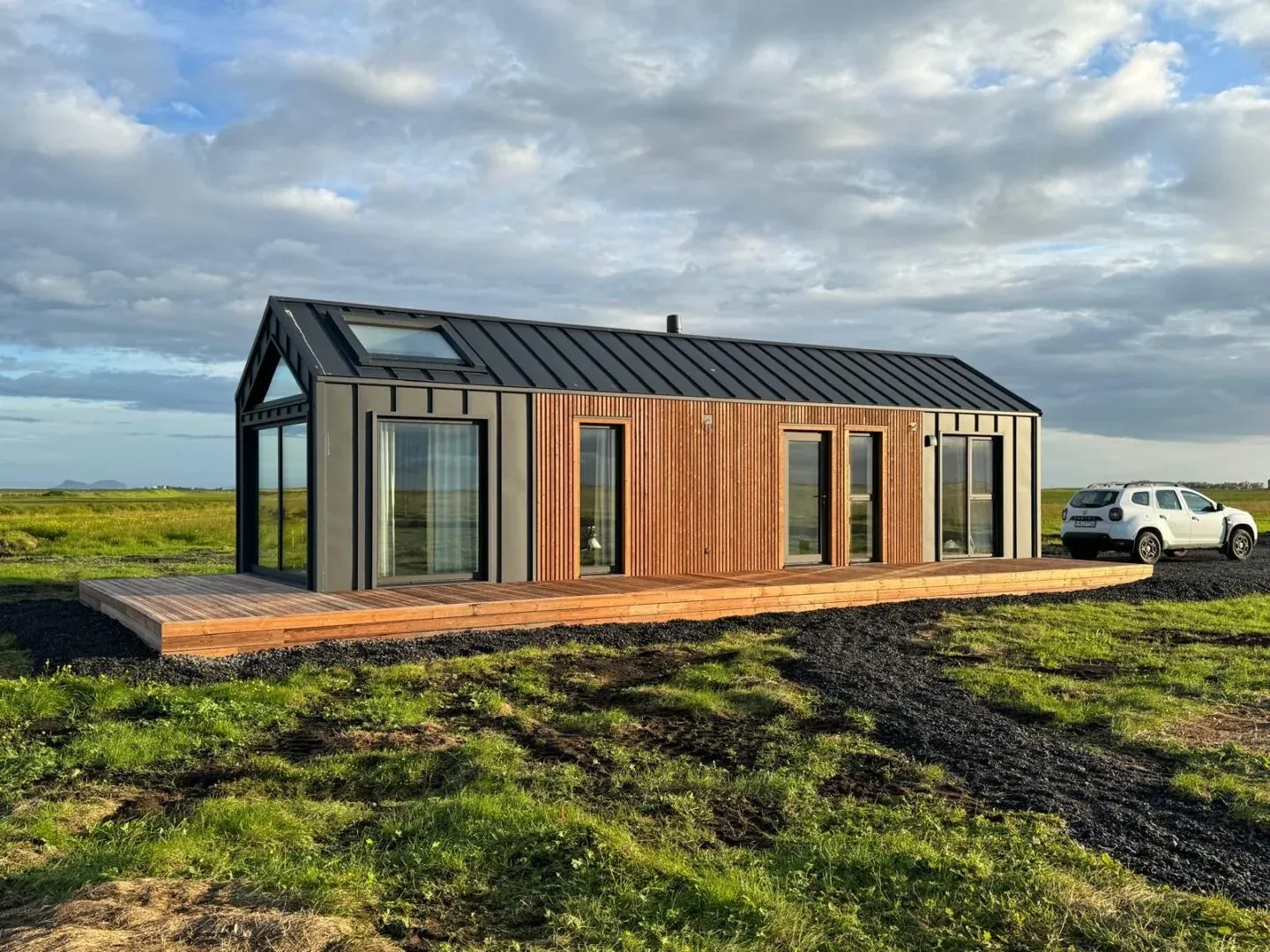Gerealiseerde modulaire woning van Bouw Art met een houten en zwarte gevel in een open landschap